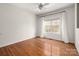 Neutral bedroom featuring hardwood floors, a ceiling fan, and a bright window at 11001 Valley Spring Dr, Charlotte, NC 28277