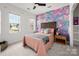Bedroom featuring carpet floors, a decorative accent wall, and natural light from two windows at 11001 Valley Spring Dr, Charlotte, NC 28277