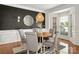 Stylish dining room featuring wainscoting, a modern light fixture, and a bay window at 11001 Valley Spring Dr, Charlotte, NC 28277
