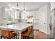 Bright kitchen with large center island, pendant lighting, white cabinets, and stainless steel appliances at 11001 Valley Spring Dr, Charlotte, NC 28277