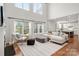 Bright living room featuring hardwood floors, large windows, and comfortable seating arrangement at 11001 Valley Spring Dr, Charlotte, NC 28277