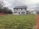 Large backyard with lush green grass, a two-story home, and a tree line at 12027 Mariners Cove Ct # 381, Lancaster, SC 29720