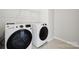 Modern laundry room featuring new white GE washer and dryer and wire shelving at 177 Glenn Dr, Mooresville, NC 28115