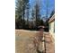 View of the backyard showing the side of the house, dry bushes, and gravel at 191 Ashford Dr, Olin, NC 28660