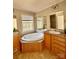 Bright bathroom featuring double sinks and a large tub next to a window at 191 Ashford Dr, Olin, NC 28660