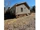 View of the side of the house featuring a brick foundation and tan vinyl siding at 191 Ashford Dr, Olin, NC 28660