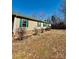 Side view of a beige home featuring a well-maintained lawn, green shutters, and a metal roof at 191 Ashford Dr, Olin, NC 28660