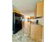 Efficient kitchen featuring wood cabinets, black refrigerator, and tile flooring at 191 Ashford Dr, Olin, NC 28660