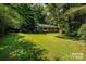 Charming home featuring a lush, green front lawn complemented by mature trees, creating a welcoming curb appeal at 2250 Arnold Dr, Charlotte, NC 28205