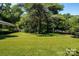 Expansive front yard with lush green grass and mature trees, providing a serene and inviting atmosphere at 2250 Arnold Dr, Charlotte, NC 28205