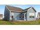 Back exterior shot showing a blue house with a patio, door, and energy efficient windows at 25966 Appleyard Ct # 1205, Lancaster, SC 29720