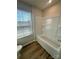 Clean bathroom featuring tub with new fixtures, tiled walls, and a window at 2616 Tillman St, Monroe, NC 28112