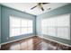 Bedroom featuring laminate floors, two windows, ceiling fan and blue walls at 279 Age Old Way, Rock Hill, SC 29732