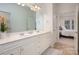 Well-lit bathroom with a double vanity, large mirror, and view into the main bedroom at 2941 Bellasera Way, Matthews, NC 28105