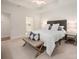 Well-lit bedroom with a tray ceiling, a stylish bench, and access to the bathroom at 2941 Bellasera Way, Matthews, NC 28105