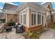 A charming exterior view of a stone and brick home featuring a cozy outdoor patio and seating area at 2941 Bellasera Way, Matthews, NC 28105