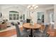 Open-concept living and dining area features a modern chandelier, plush chairs, and abundant natural light at 2941 Bellasera Way, Matthews, NC 28105