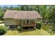 Back of home with a wooden deck and stairs, complemented by lush greenery and a white picket fence at 3039 Paraham S Rd, York, SC 29745