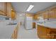 Functional kitchen featuring wood cabinets, light countertops, white appliances, and access to the laundry room for added convenience at 3039 Paraham S Rd, York, SC 29745