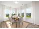 Bright dining room with modern table, chairs, rug, and multiple windows with bright natural light at 40189 Crooked Stick Dr # 1205, Lancaster, SC 29720