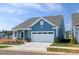 Exterior of a charming blue home featuring an attached garage and manicured landscaping at 40189 Crooked Stick Dr # 1205, Lancaster, SC 29720