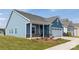 Charming blue home featuring a covered porch, attached garage, and well-maintained landscaping at 40189 Crooked Stick Dr # 1205, Lancaster, SC 29720