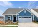 Charming blue home with well-maintained landscaping, attached garage, and inviting front entrance at 40189 Crooked Stick Dr # 1205, Lancaster, SC 29720