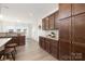 Modern kitchen with dark wood cabinetry, light countertops, and stainless steel appliances overlooking a dining area at 40189 Crooked Stick Dr # 1205, Lancaster, SC 29720