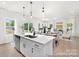 Open-concept kitchen flows into the living and dining areas, featuring a large island with quartz countertops at 40189 Crooked Stick Dr # 1235, Lancaster, SC 29720