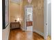 Hallway leading into bathroom, showcasing hardwood floors, neutral walls and decorative lighting and fixtures at 4336 Tottenham Rd, Charlotte, NC 28226