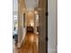 Hallway view leading to bedroom and bathroom, featuring hardwood floors and an elegant chandelier at 4336 Tottenham Rd, Charlotte, NC 28226