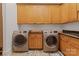 Well-lit laundry room with front load washer and dryer and custom cabinetry storage space at 4336 Tottenham Rd, Charlotte, NC 28226