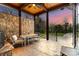Covered patio with stone wall, dining table, ceiling fan, and access to the manicured backyard at 4336 Tottenham Rd, Charlotte, NC 28226