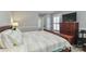 Comfortable bedroom features a wooden bed frame, neutral walls, shuttered windows, and a television at 632 N Oakland Ave # Pt1, Statesville, NC 28677