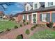 Stunning brick home entrance with lush green landscaping, a brick walkway, and a welcoming green door at 632 N Oakland Ave # Pt1, Statesville, NC 28677