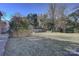 The backyard features an expansive lawn with mature trees, a wood fence, and green shrubs at 7526 Dorn Cir, Charlotte, NC 28212