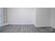 The basement is spacious with modern gray wood-look flooring, white walls, and trim at 7526 Dorn Cir, Charlotte, NC 28212