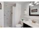 This bathroom features a marble-tiled shower, white walls, vanity, mirror, and towel rack at 7526 Dorn Cir, Charlotte, NC 28212