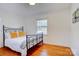Bedroom with a metal bed frame, hardwood floors, and natural light from a window at 7526 Dorn Cir, Charlotte, NC 28212