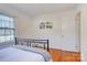 Bedroom with a metal bed frame, hardwood floors, and natural light from a large window at 7526 Dorn Cir, Charlotte, NC 28212