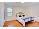 Bright bedroom featuring hardwood floors, a window for natural light and a comfortable iron bed frame at 7526 Dorn Cir, Charlotte, NC 28212