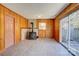 This wood-paneled living room has a wood burning stove, slider door, and wood-look flooring at 7526 Dorn Cir, Charlotte, NC 28212