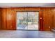 This wood-paneled living room has a slider door, and wood-look flooring leading out to the backyard at 7526 Dorn Cir, Charlotte, NC 28212