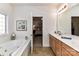 Bathroom with double sinks, shower and large white tub, and doorway to bedroom at 1012 Preakness Blvd, Indian Trail, NC 28079