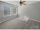 Bright bedroom featuring carpeted floors, two windows, and a ceiling fan at 10462 Trolley Run Dr, Cornelius, NC 28031