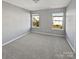 Clean, light-filled bedroom featuring neutral walls, soft carpet, and two bright windows at 10462 Trolley Run Dr, Cornelius, NC 28031
