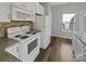 Bright kitchen featuring white appliances, granite countertops, and sleek backsplash at 10462 Trolley Run Dr, Cornelius, NC 28031