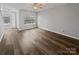 Bright living room featuring hardwood floors, a ceiling fan, and natural light from a large window at 10462 Trolley Run Dr, Cornelius, NC 28031