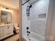Bathroom with tile shower and bathtub combo featuring a rain shower head and modern black fixtures at 10929 Lassen Ct, Charlotte, NC 28214