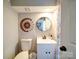 A half bathroom featuring a decorative mirror, a small sink, and standard toilet at 10929 Lassen Ct, Charlotte, NC 28214